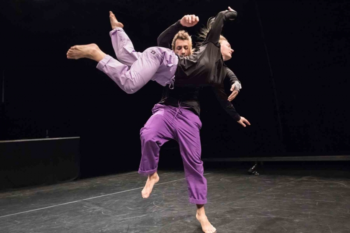 Two performers dancing energetically on stage.