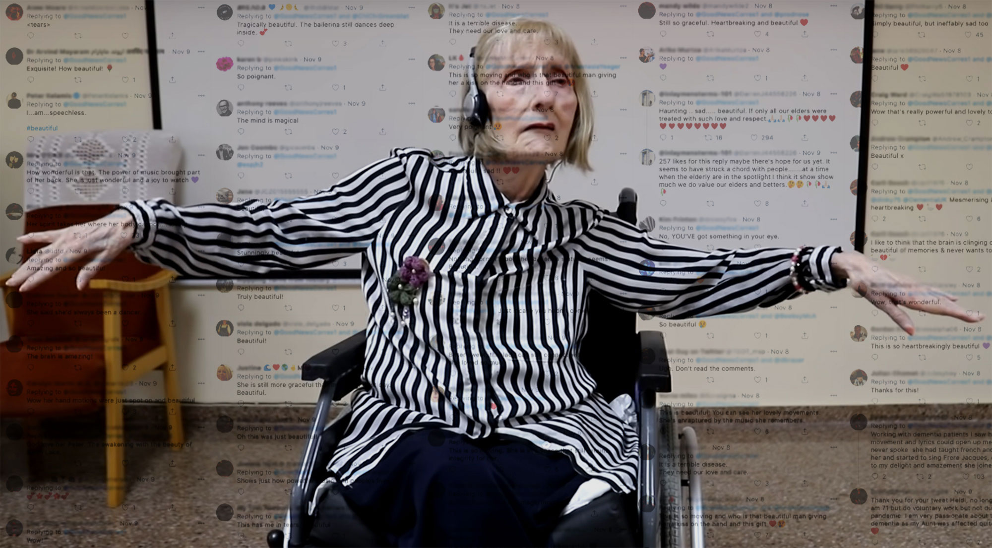 Elderly woman in wheelchair extending arms, walls covered in text.