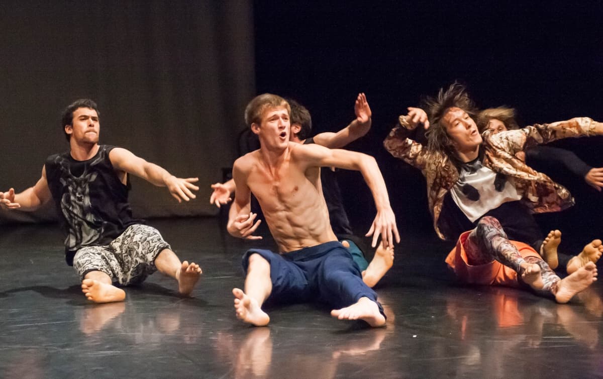 Energetic dancers perform on stage, expressive movements.
