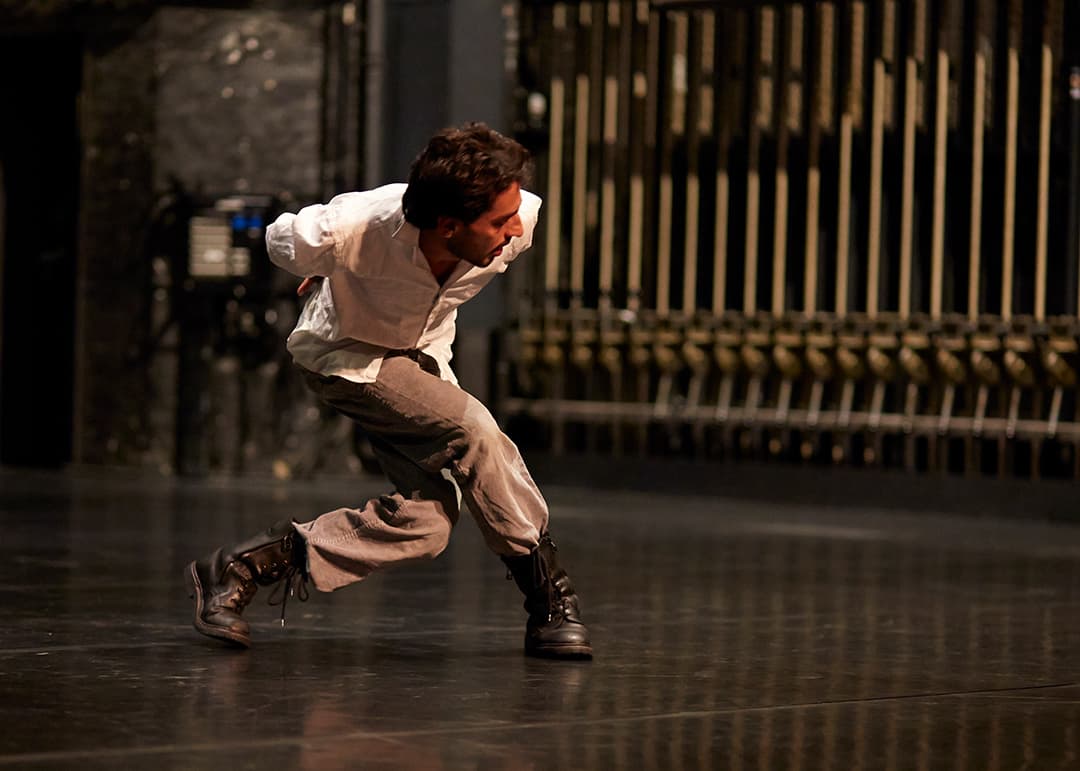 Dancer performing energetically on stage.