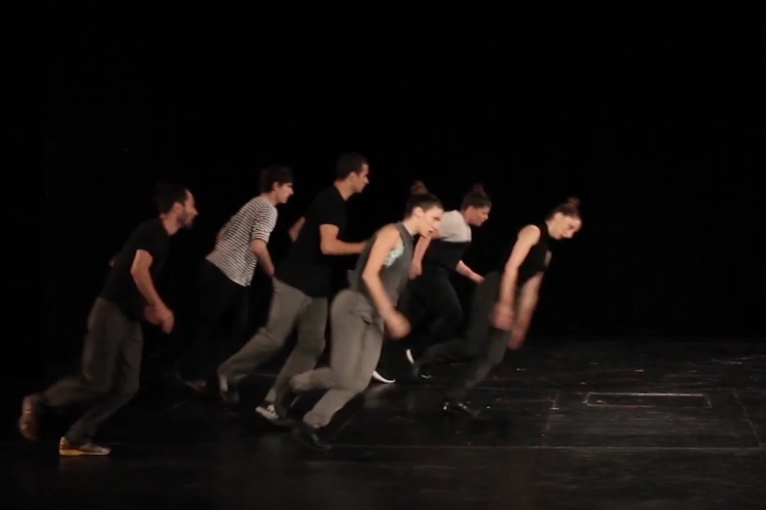 Group performing contemporary dance on stage.
