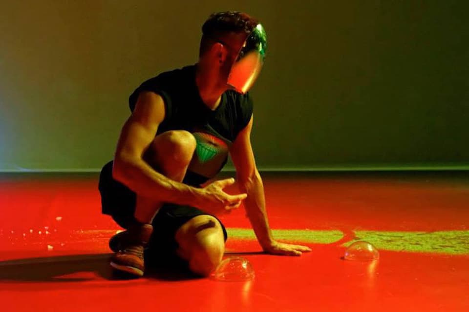 Person kneeling on red floor with helmet