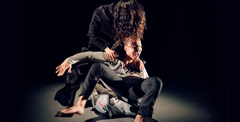 Two dancers perform an intense contemporary dance piece.