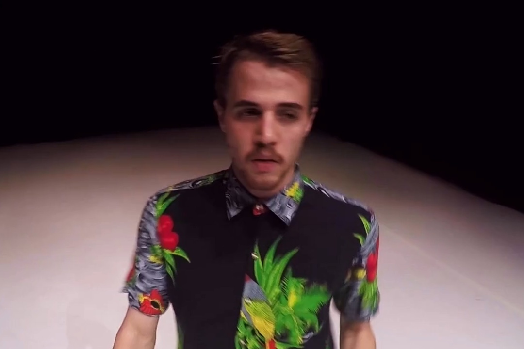 Man wearing floral shirt on stage.