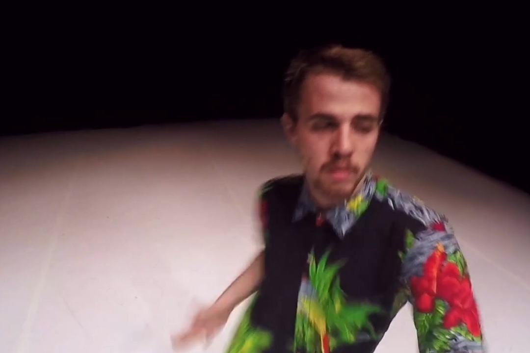 Man in vibrant shirt on stage.