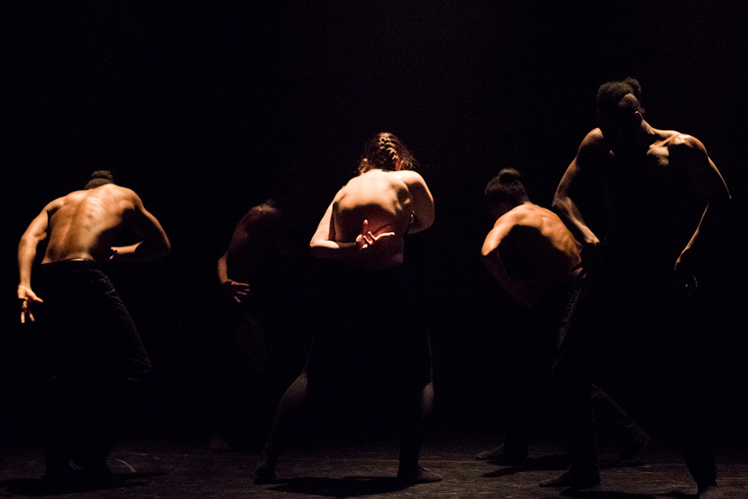 Dancers on stage in dramatic lighting