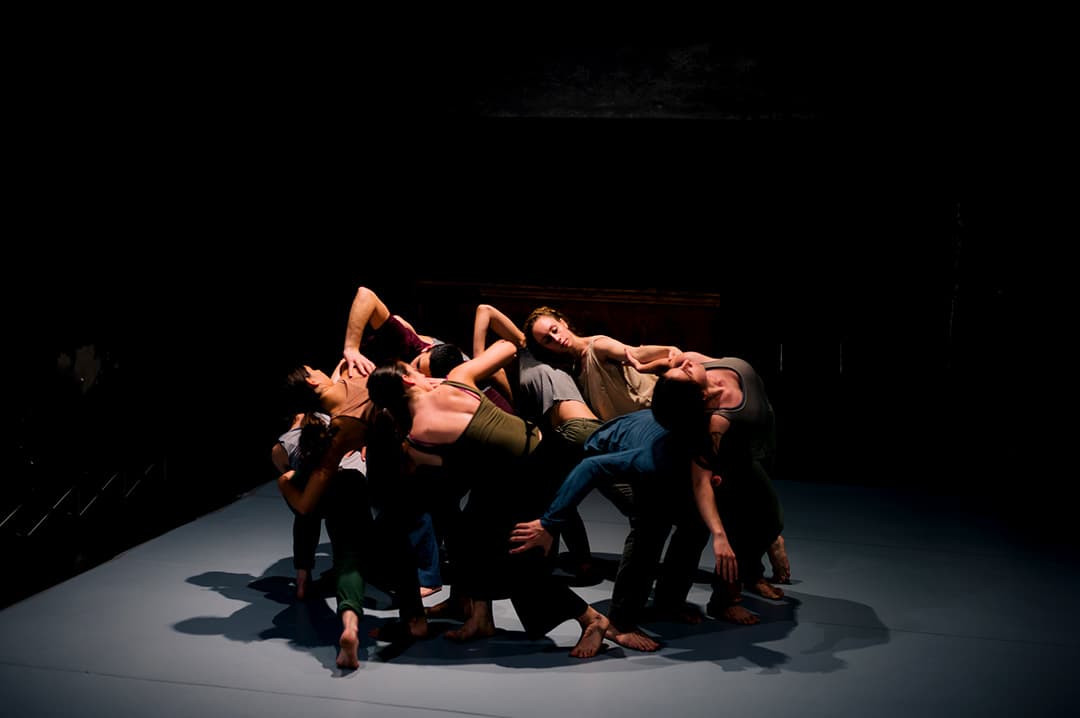 Dancers entwined in artistic performance on stage.