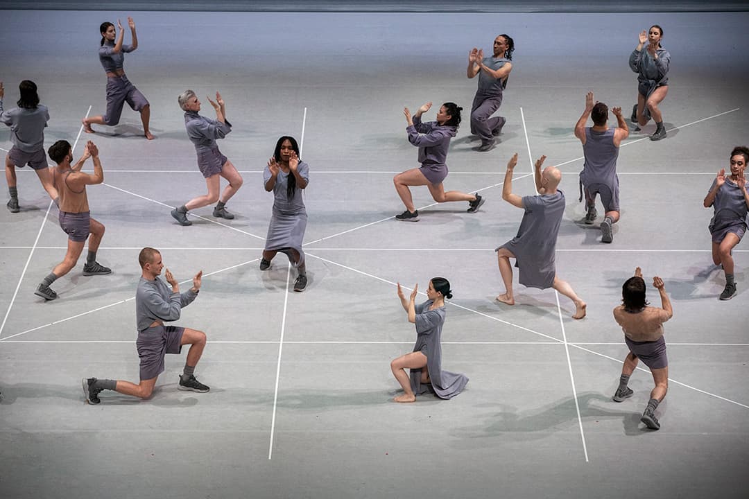 Contemporary dancers performing in unison on stage.