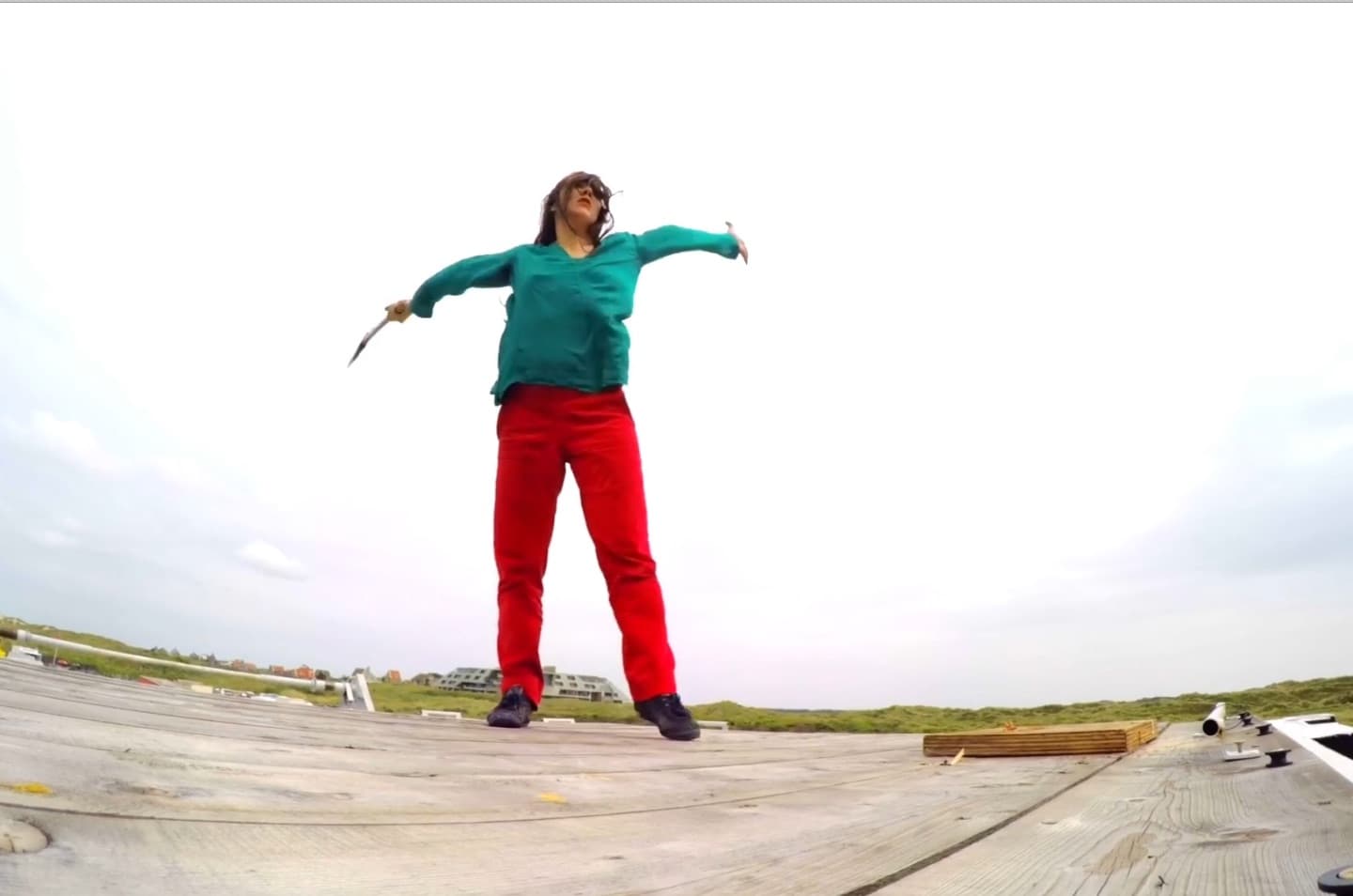 Person standing on wooden platform with arms raised