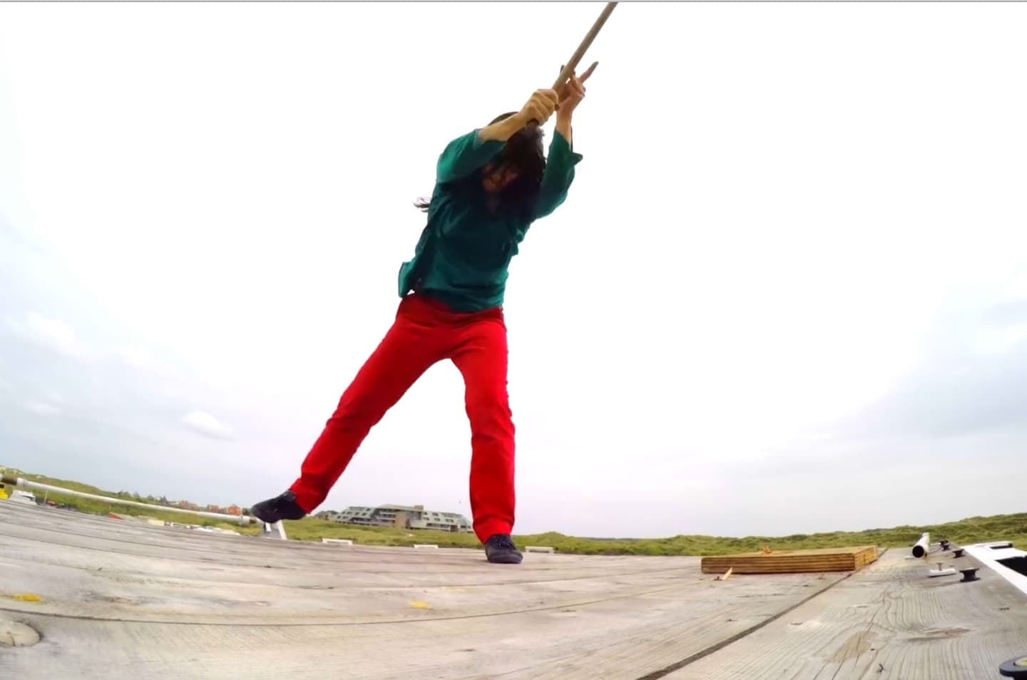 Person performing martial arts on wooden platform.