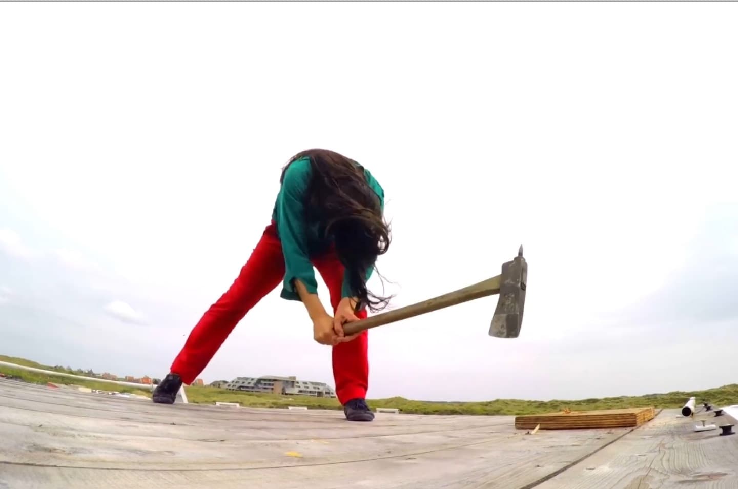 Person using a sledgehammer on wooden deck.