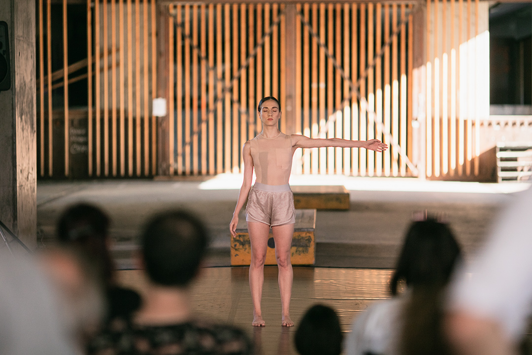 Solo dancer performing on stage, audience watching