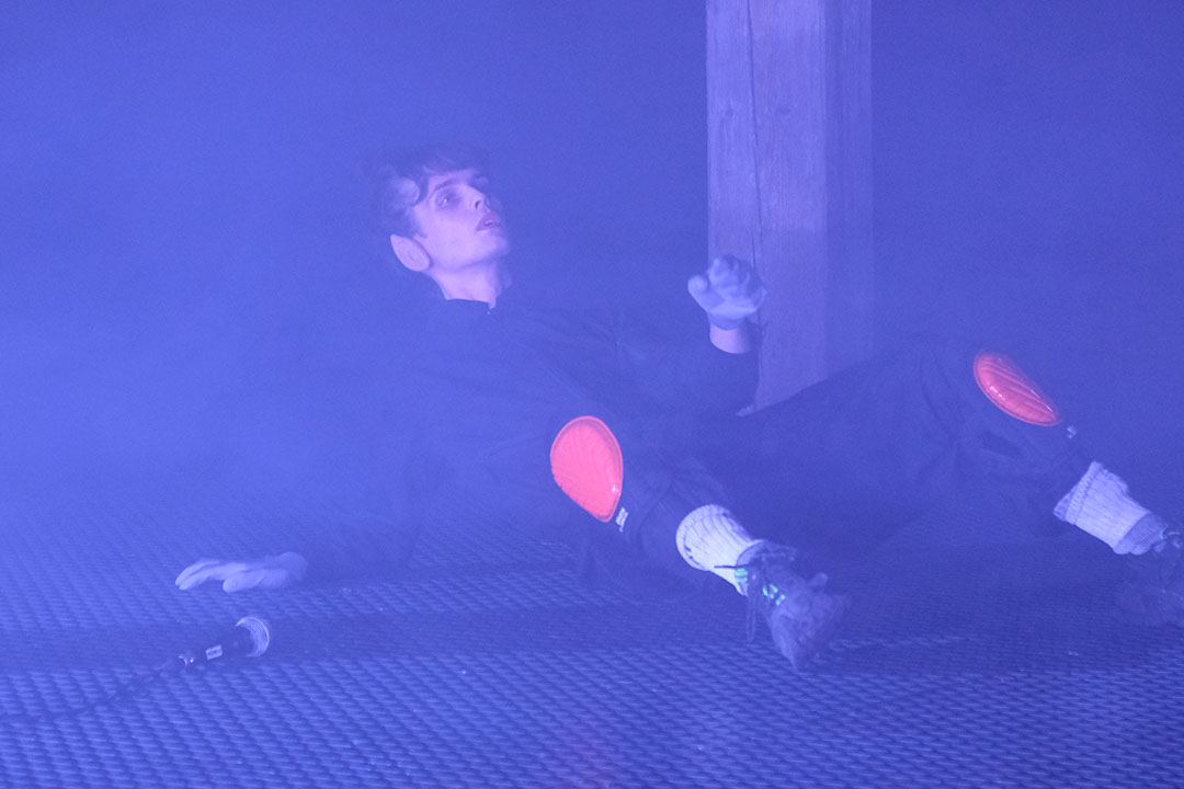 Person in foggy room on stage with microphone.