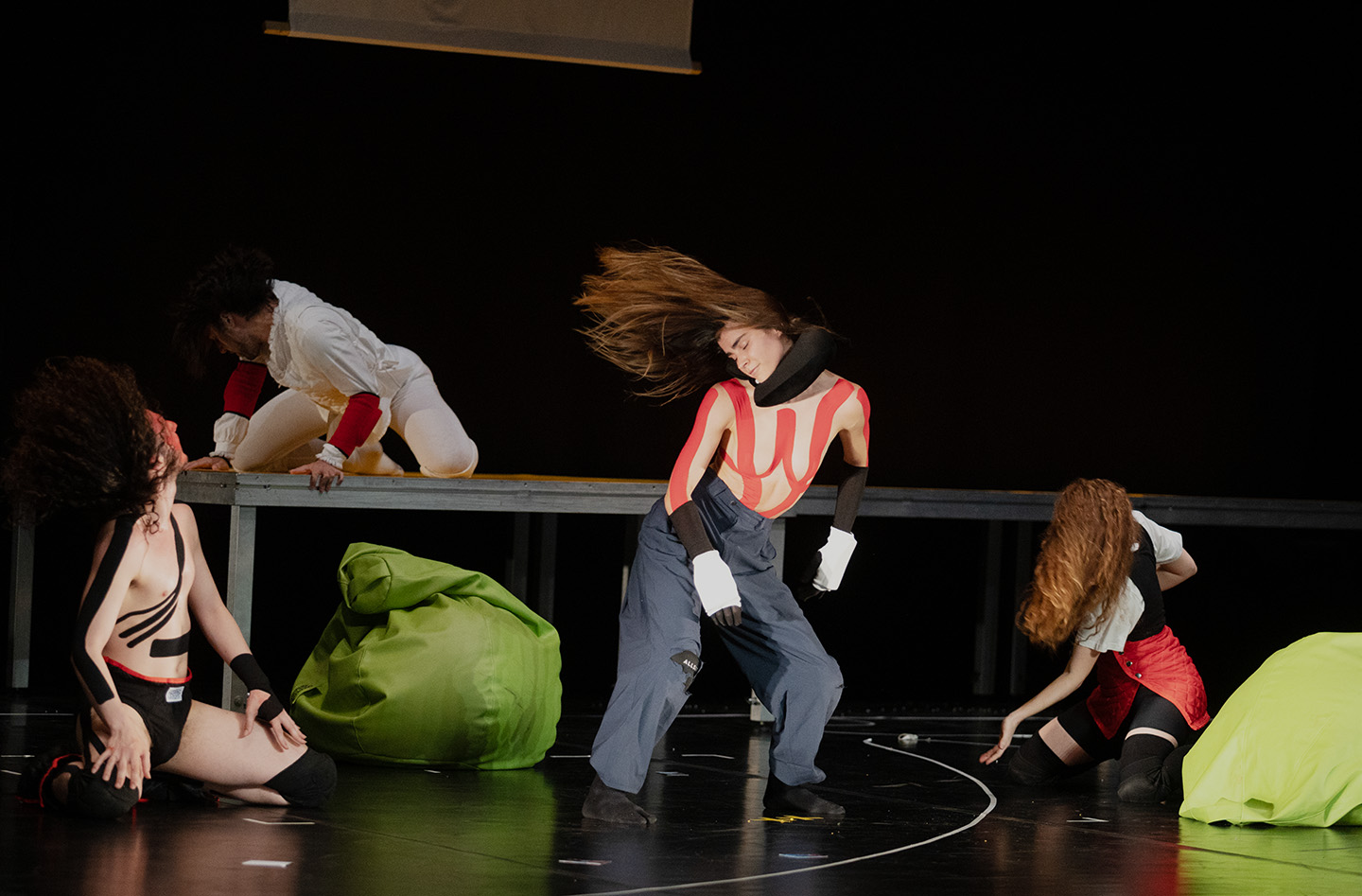 Dancers performing on stage with dynamic movements.
