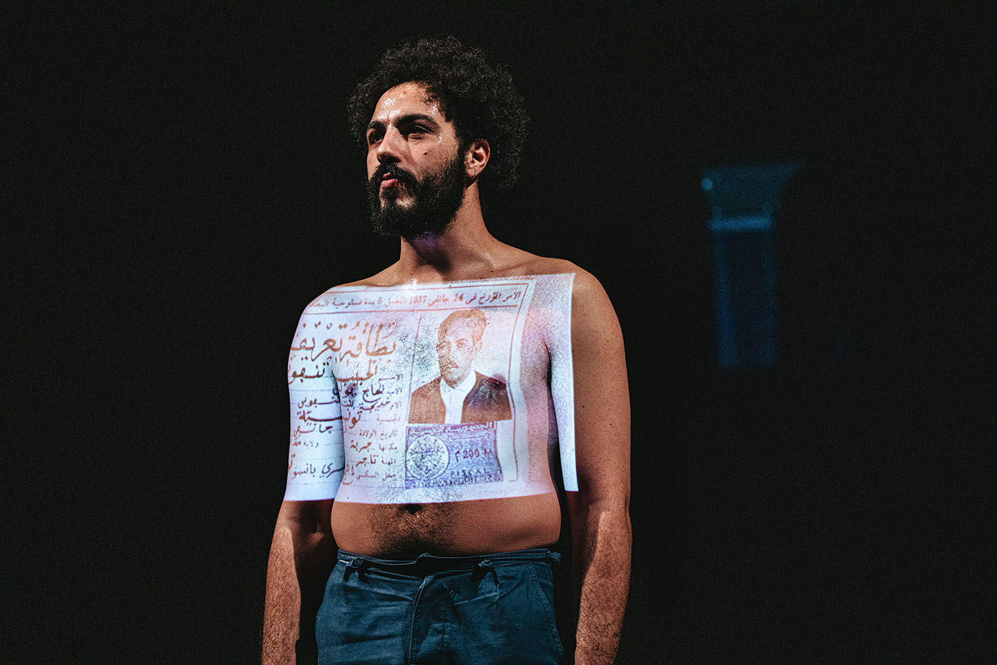 Man with newspaper text projected on chest.