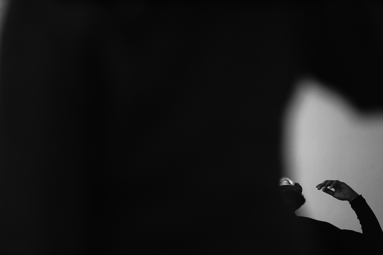 Silhouette of person in dark abstract setting.