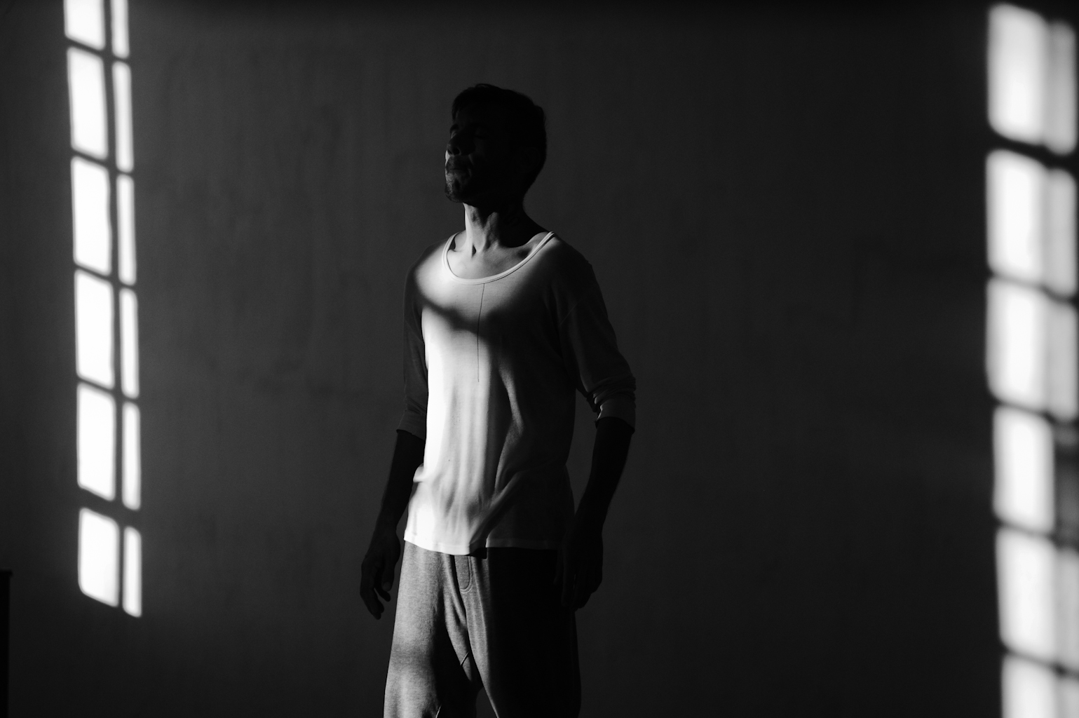 Silhouette of a person in dappled light indoors.