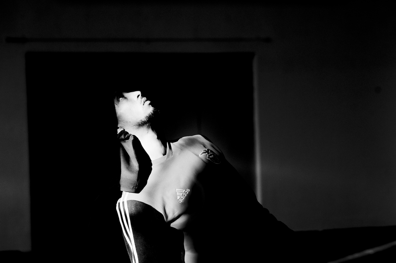 Silhouette of hooded person in dramatic lighting.