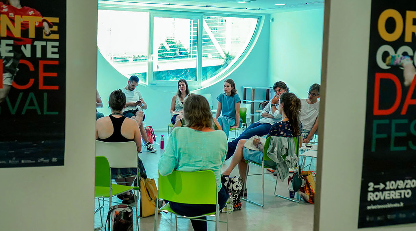 People discussing in dance festival meeting room.