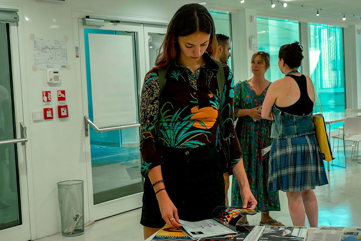 Woman browsing magazines at an exhibition.