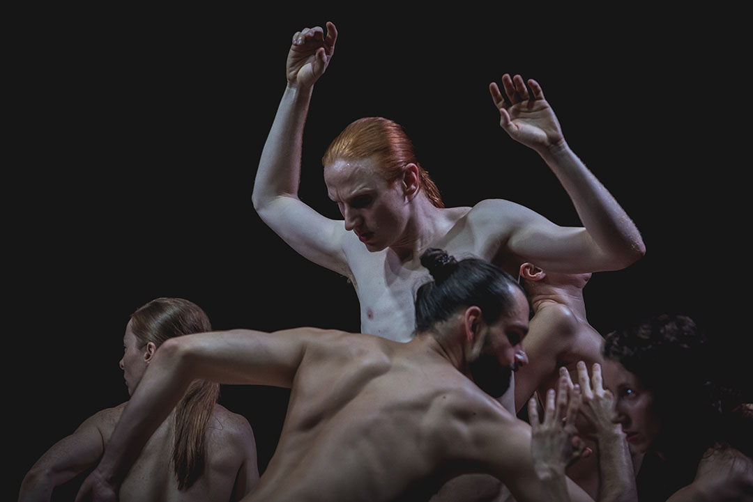 Contemporary dancers performing expressive movement on stage.