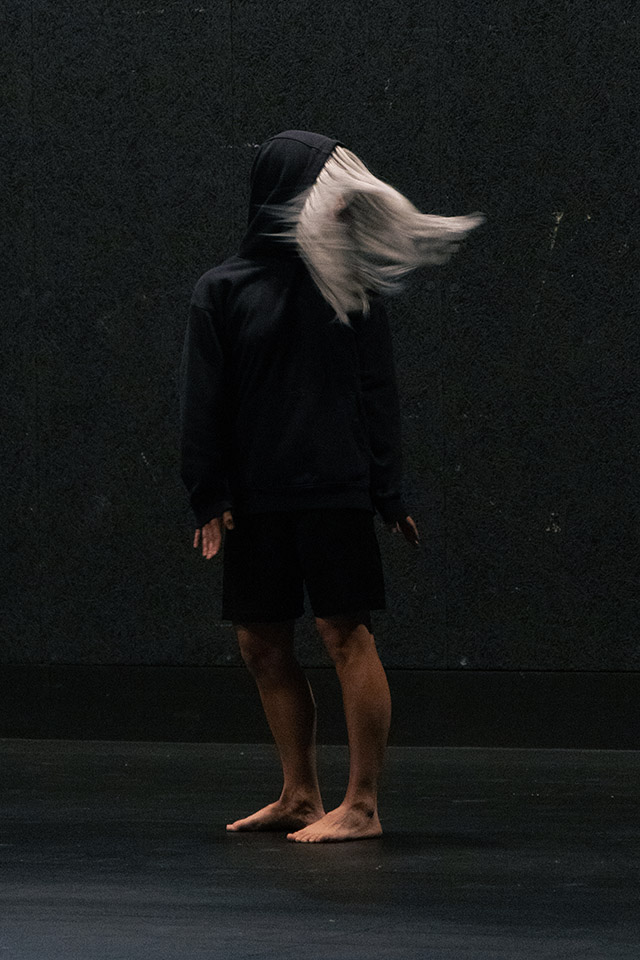 Person in black hoodie with their hair sweeping left.