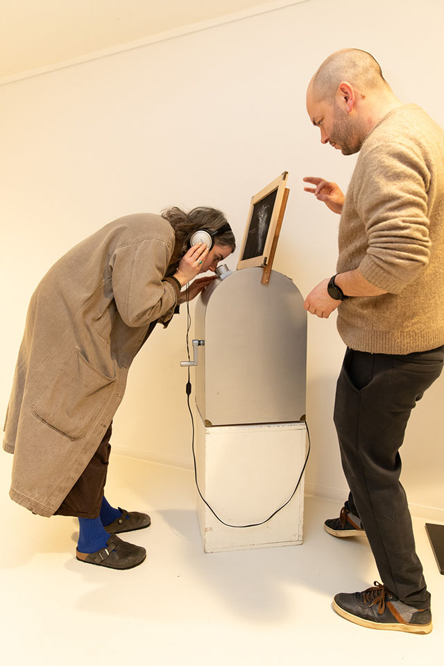 People interacting with small gallery installation device