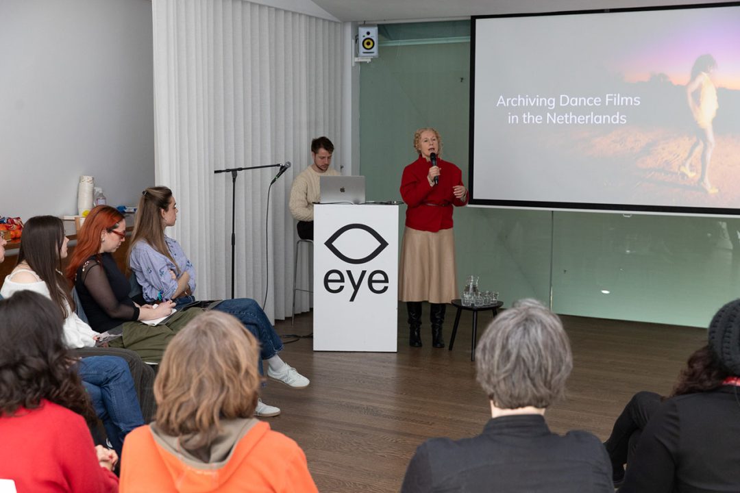 Speaker presenting archiving dance films to seated audience