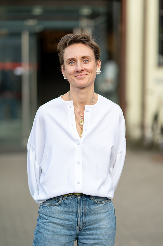 Person in white blouse and jeans outdoors