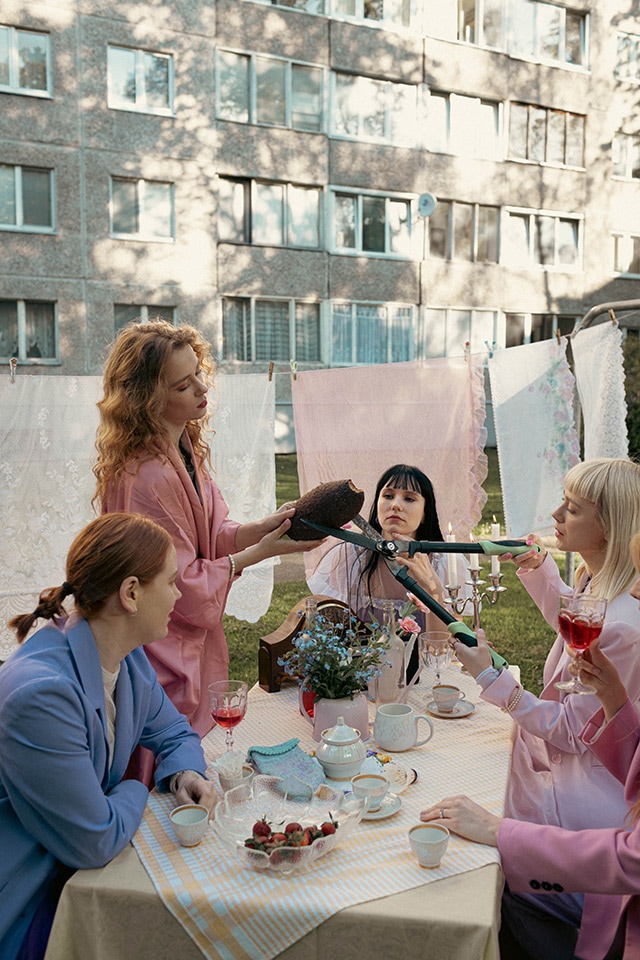 Women trimming hedgehog at outdoor tea table
