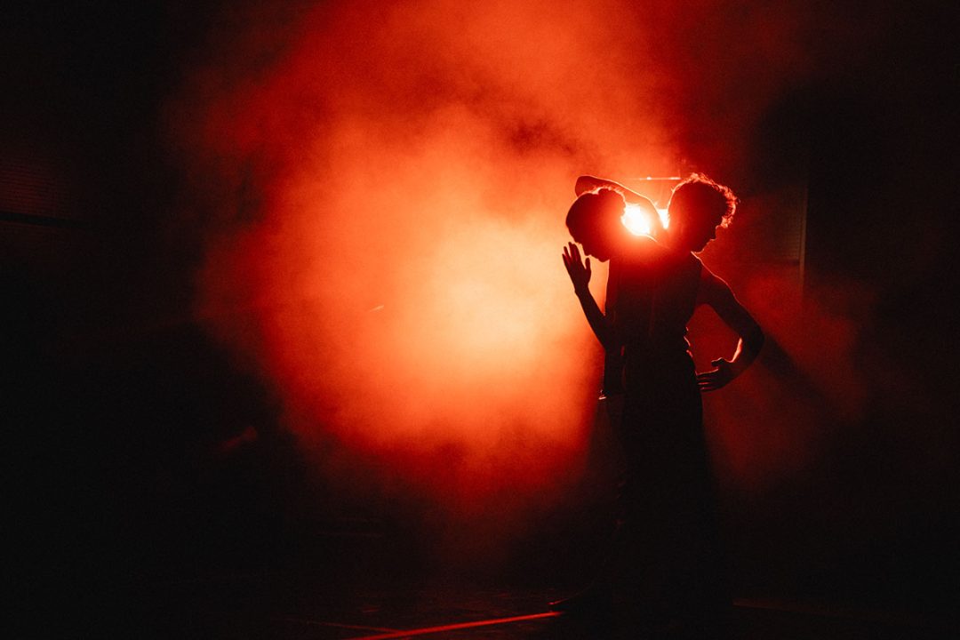 Silhouetted couple against dramatic red backlight with smoke
