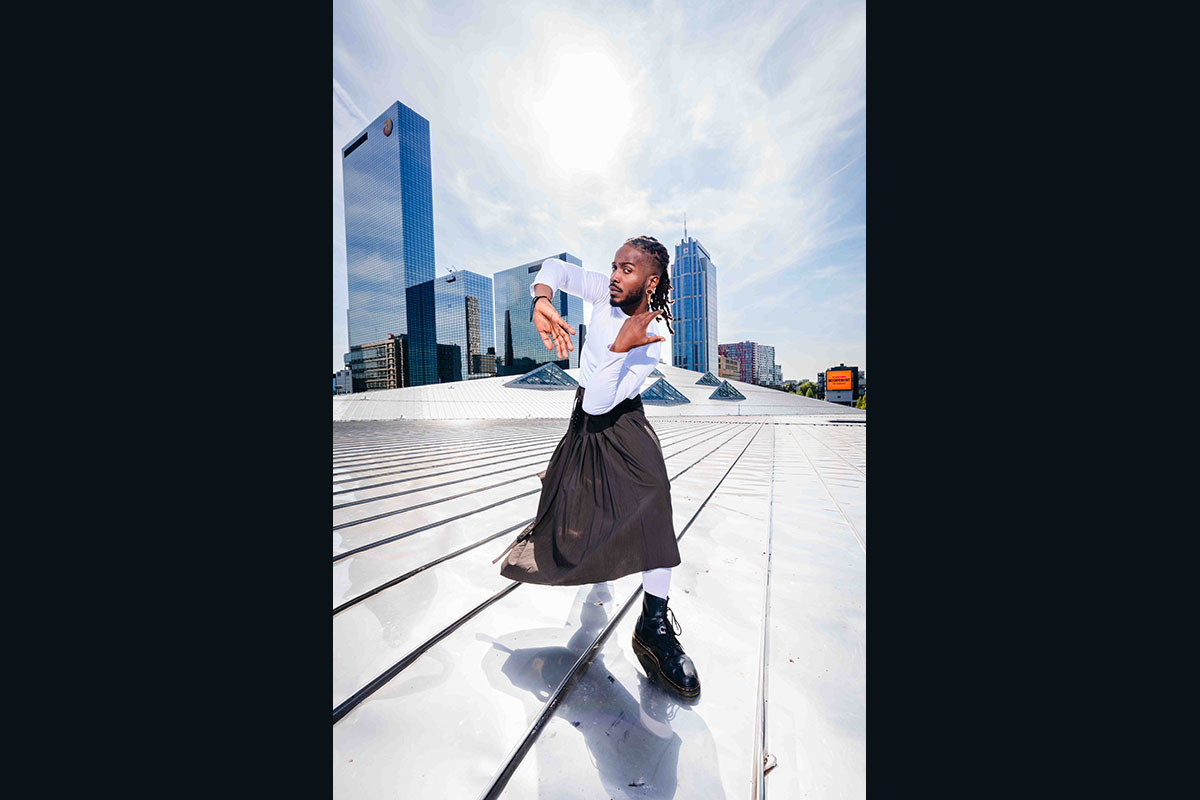 Dancer posing on rooftop with city skyline