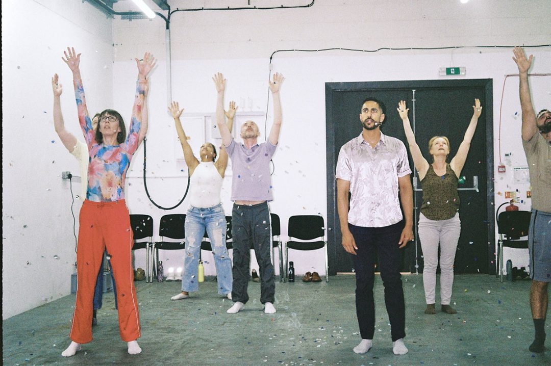 Group raising arms during indoor workshop session