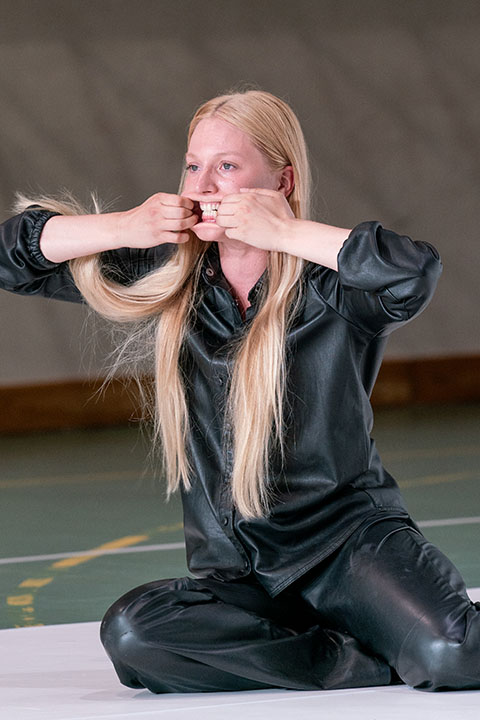 Woman sitting cross-legged pulling hair with mouth