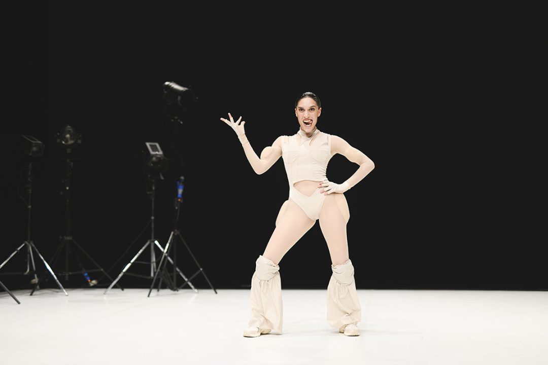 Dancer posing energetically in a studio with lighting equipment